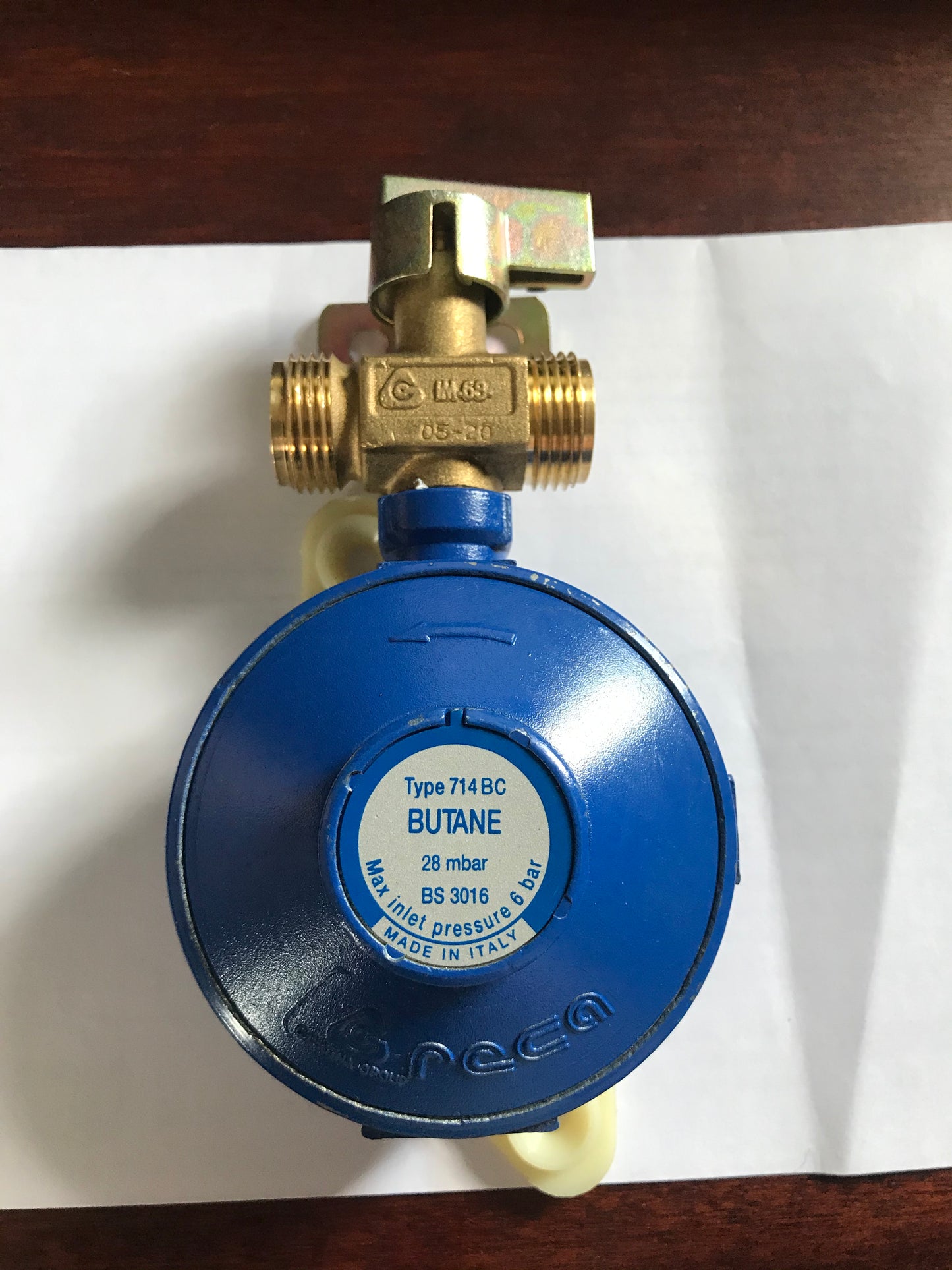 Blue gas regulator with brass manual changeover valve on a white background